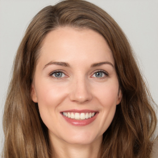 Joyful white young-adult female with long  brown hair and green eyes