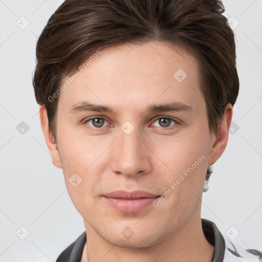 Joyful white young-adult male with short  brown hair and grey eyes