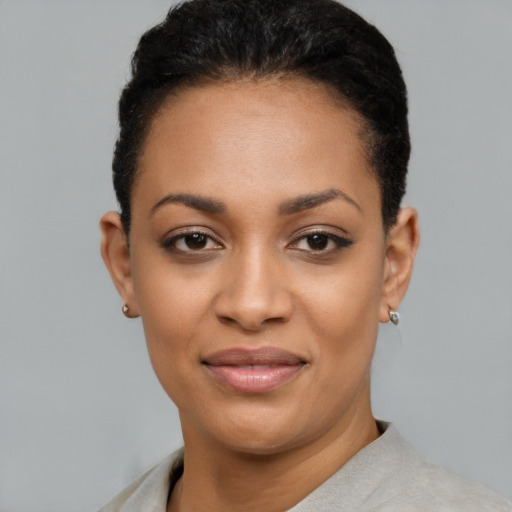 Joyful black young-adult female with short  black hair and brown eyes