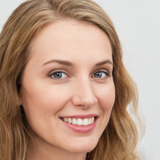 Joyful white young-adult female with long  brown hair and blue eyes