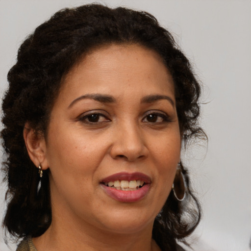 Joyful latino adult female with medium  brown hair and brown eyes