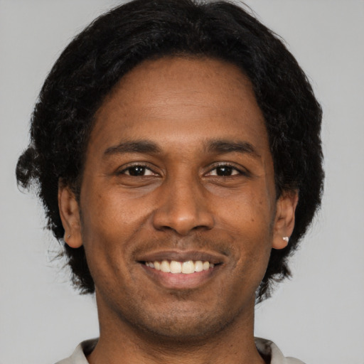 Joyful black young-adult male with short  black hair and brown eyes