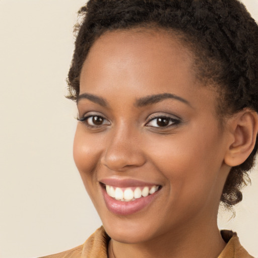 Joyful black young-adult female with long  brown hair and brown eyes