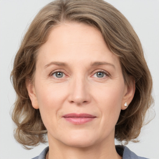 Joyful white adult female with medium  brown hair and grey eyes