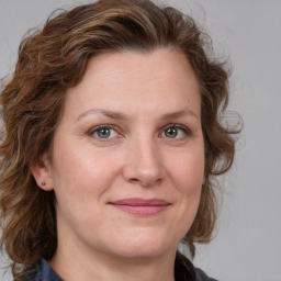 Joyful white adult female with medium  brown hair and blue eyes