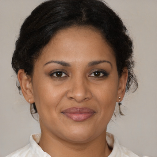 Joyful latino adult female with medium  brown hair and brown eyes