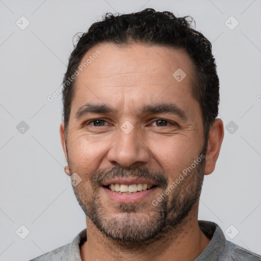 Joyful white adult male with short  black hair and brown eyes