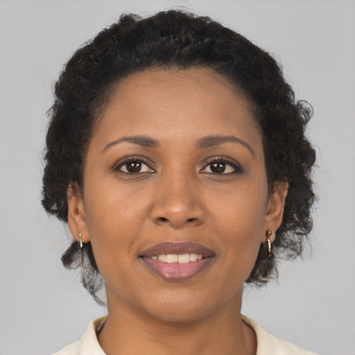Joyful black young-adult female with short  brown hair and brown eyes