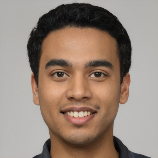 Joyful latino young-adult male with short  black hair and brown eyes