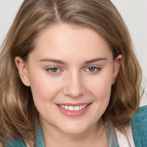 Joyful white young-adult female with medium  brown hair and blue eyes