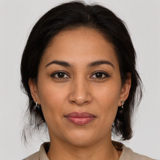 Joyful latino adult female with medium  brown hair and brown eyes