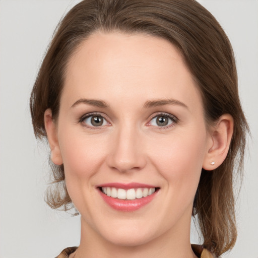 Joyful white young-adult female with medium  brown hair and grey eyes