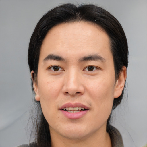 Joyful asian young-adult male with medium  brown hair and brown eyes