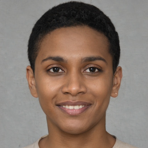 Joyful black young-adult female with short  black hair and brown eyes