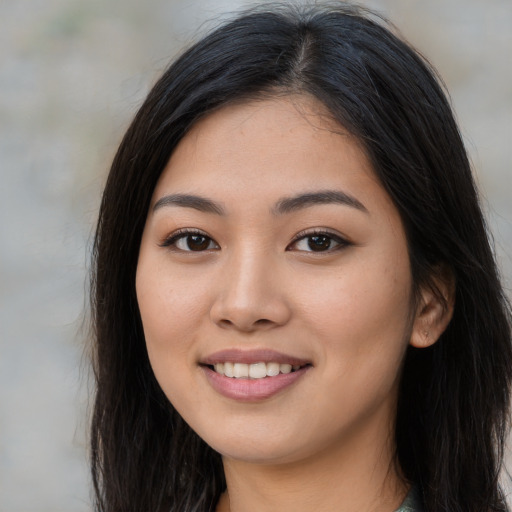 Joyful asian young-adult female with long  brown hair and brown eyes
