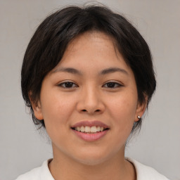 Joyful asian young-adult female with medium  brown hair and brown eyes