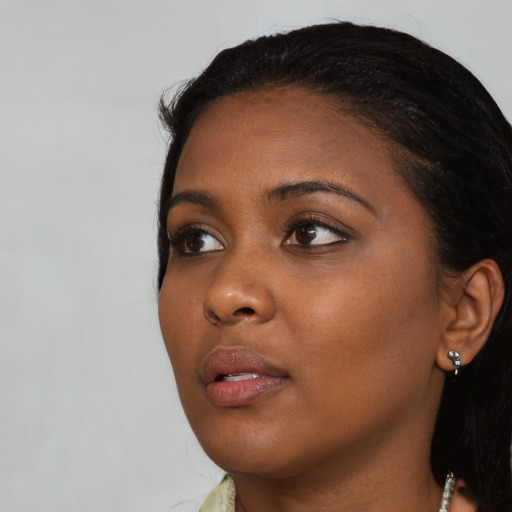 Joyful black young-adult female with medium  black hair and brown eyes