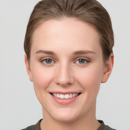 Joyful white young-adult female with short  brown hair and grey eyes