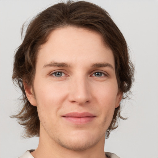 Joyful white young-adult male with medium  brown hair and grey eyes