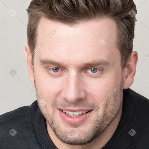 Joyful white adult male with short  brown hair and blue eyes