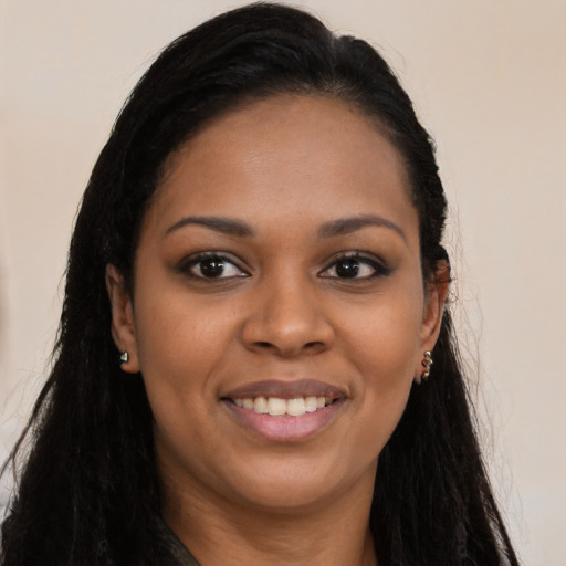 Joyful black young-adult female with long  brown hair and brown eyes