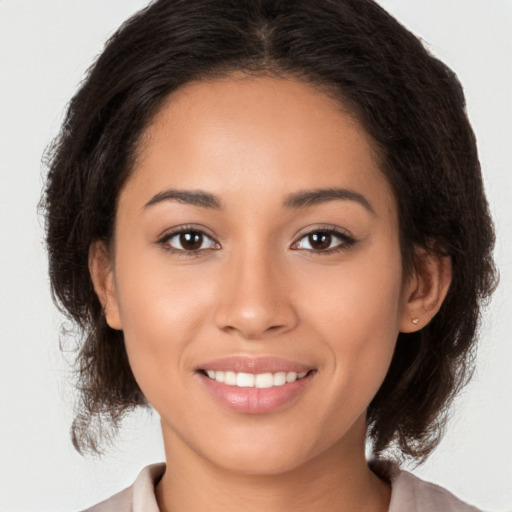 Joyful latino young-adult female with medium  brown hair and brown eyes