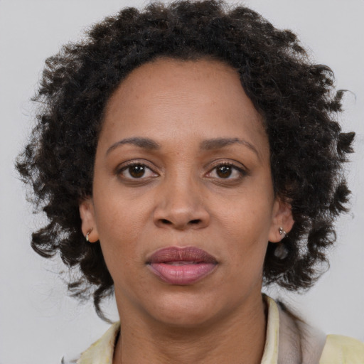 Joyful black adult female with medium  brown hair and brown eyes