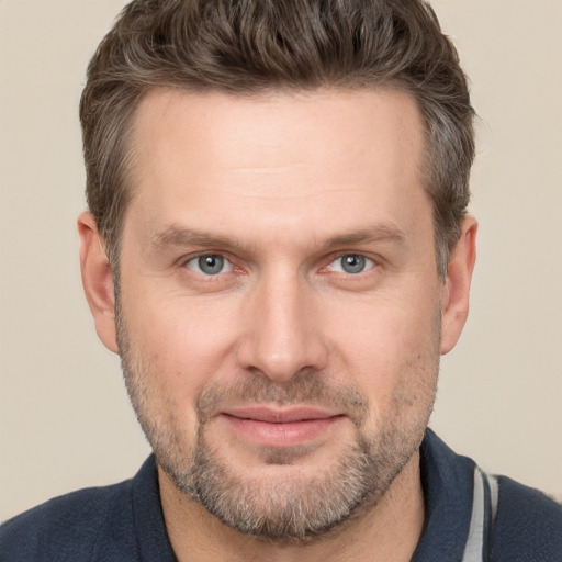 Joyful white adult male with short  brown hair and grey eyes