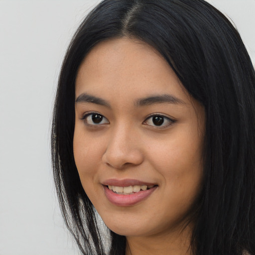 Joyful asian young-adult female with long  black hair and brown eyes