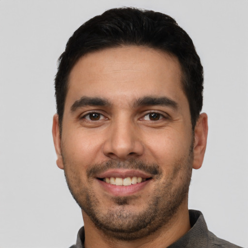 Joyful white young-adult male with short  black hair and brown eyes