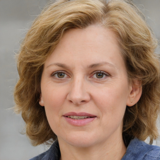 Joyful white adult female with medium  brown hair and blue eyes