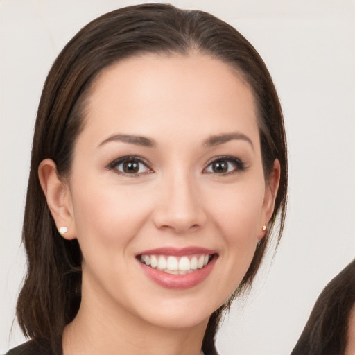 Joyful white young-adult female with long  brown hair and brown eyes