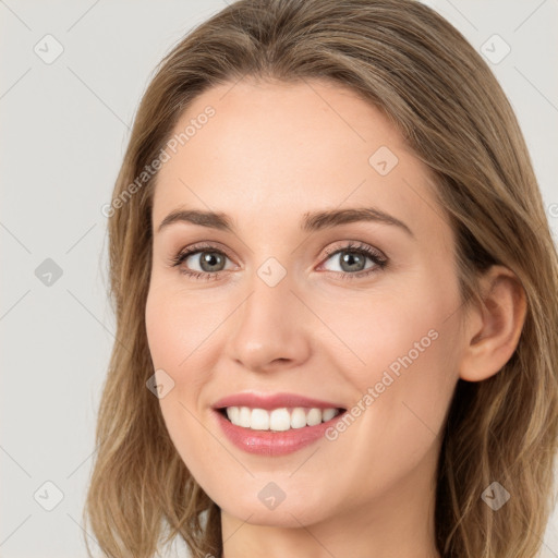 Joyful white young-adult female with long  brown hair and grey eyes