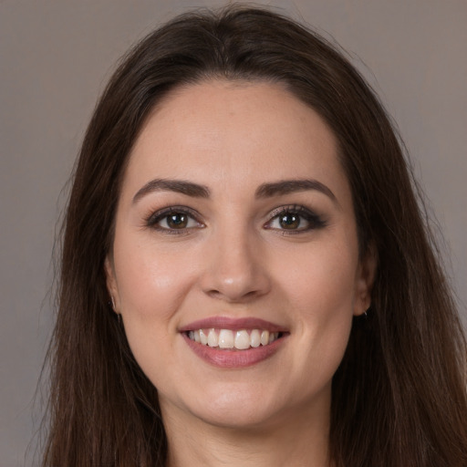 Joyful white young-adult female with long  brown hair and brown eyes