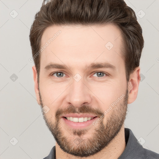 Joyful white young-adult male with short  brown hair and grey eyes