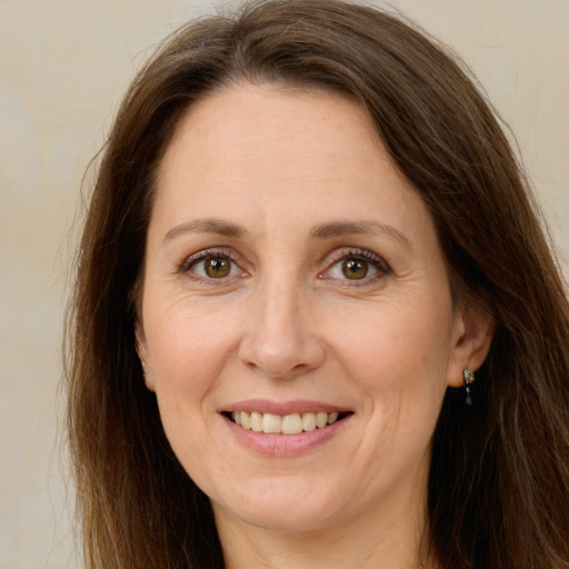 Joyful white adult female with long  brown hair and green eyes