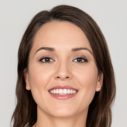 Joyful white young-adult female with long  brown hair and brown eyes