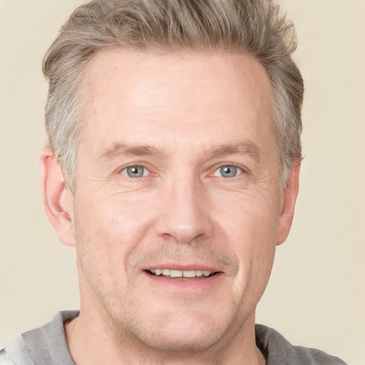 Joyful white adult male with short  blond hair and grey eyes