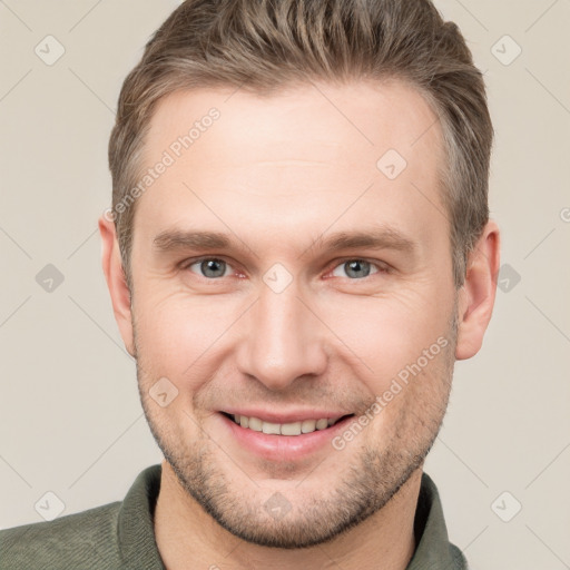 Joyful white young-adult male with short  brown hair and grey eyes