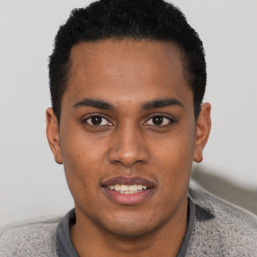 Joyful black young-adult male with short  brown hair and brown eyes