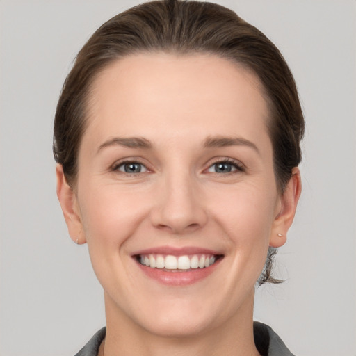 Joyful white young-adult female with short  brown hair and grey eyes