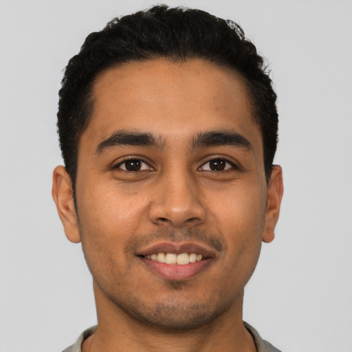 Joyful latino young-adult male with short  brown hair and brown eyes