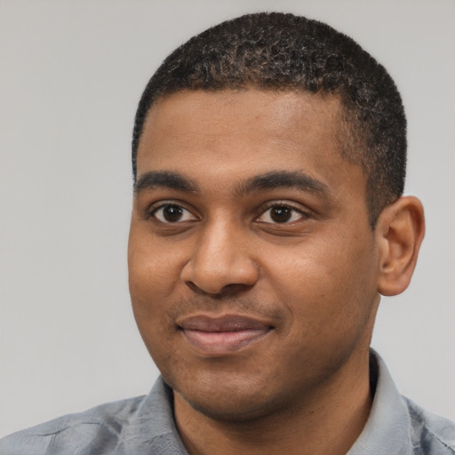 Joyful black young-adult male with short  black hair and brown eyes