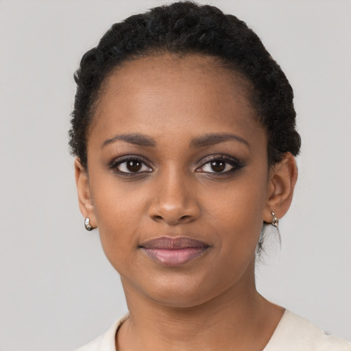 Joyful black young-adult female with short  black hair and brown eyes