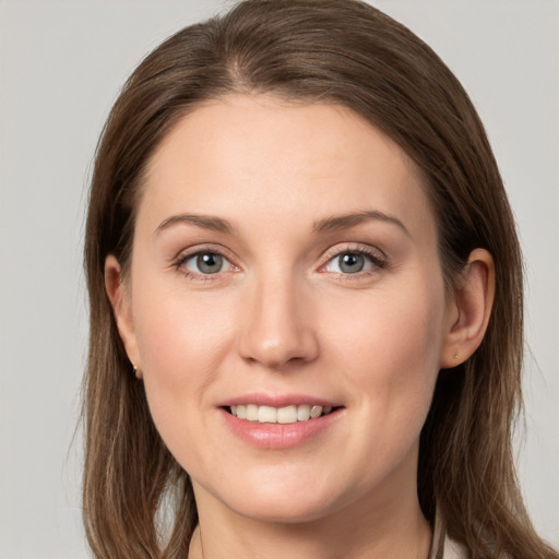 Joyful white young-adult female with long  brown hair and grey eyes