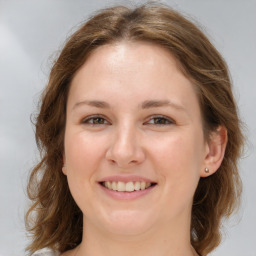 Joyful white young-adult female with medium  brown hair and green eyes