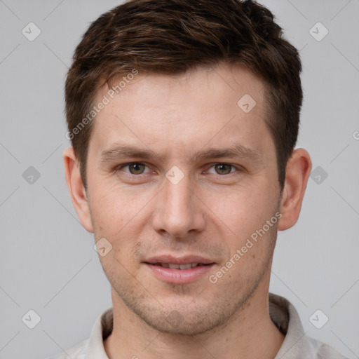 Joyful white young-adult male with short  brown hair and grey eyes