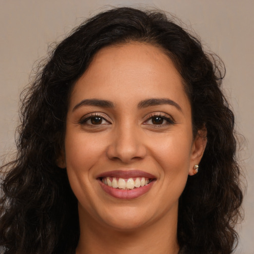 Joyful latino young-adult female with long  brown hair and brown eyes