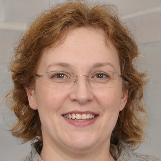 Joyful white adult female with medium  brown hair and blue eyes