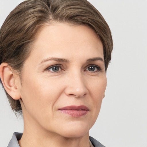 Joyful white adult female with medium  brown hair and grey eyes